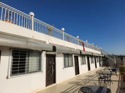 a building with a balcony with tables and chairs at Auberge rahha