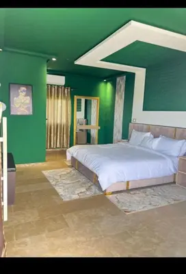 a bedroom with a large bed with green walls at Auberge rahha