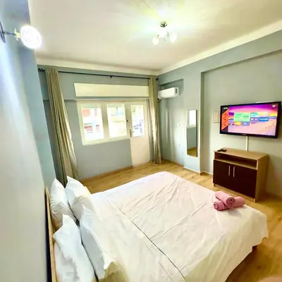 a bedroom with a white bed and a flat screen tv at Appartement centre ville avec Wifi 100Mo in Fès