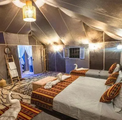 a room with two beds with swans in it at Merzouga Lovely Luxury Camp in Merzouga