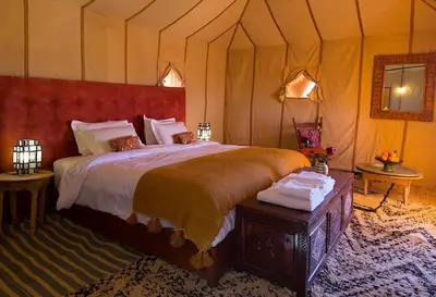 a bedroom with a large bed in a tent at Merzouga Lovely Luxury Camp in Merzouga