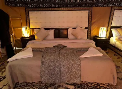 a bedroom with two beds and two lamps at Merzouga Lovely Luxury Camp in Merzouga