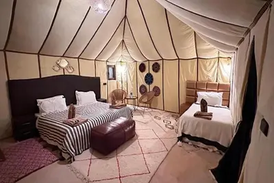 a bedroom with two beds in a tent at Merzouga Lovely Luxury Camp in Merzouga