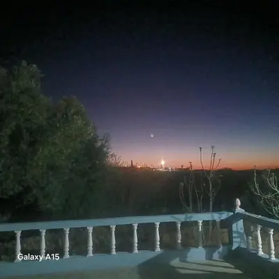 a night view of a bridge with the moon in the sky at Maison d'Azur in Imouzzer Kandar