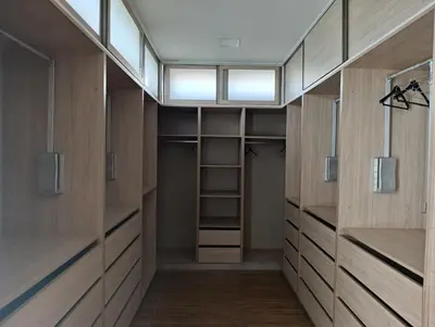 a walk in closet with wooden cabinets and shelves at Villa in Meknès