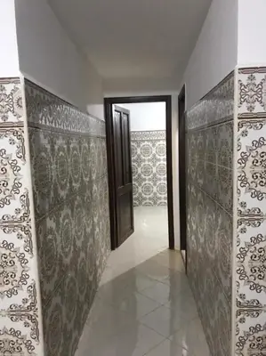 a hallway with a door and a wall with patterns at Duplex Rahma in Fès