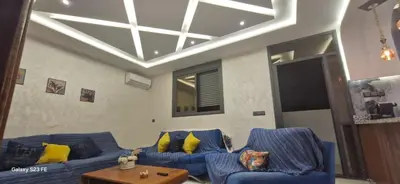a living room with two blue couches and a table at Studio Gate Fes in Fès