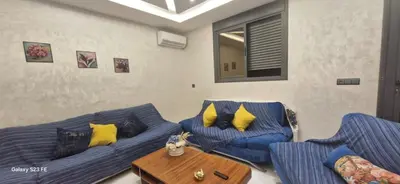a living room with two blue couches and a table at Studio Gate Fes in Fès