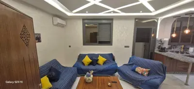 a living room with blue couches with yellow pillows at Studio Gate Fes in Fès