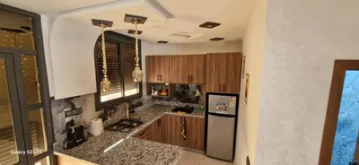 a kitchen with wooden cabinets and a stainless steel refrigerator at Studio Gate Fes in Fès