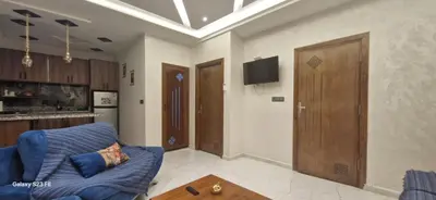 a living room with a blue couch and a door at Studio Gate Fes in Fès