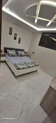 a bedroom with a large bed in a room with marble floors at Studio Gate Fes in Fès