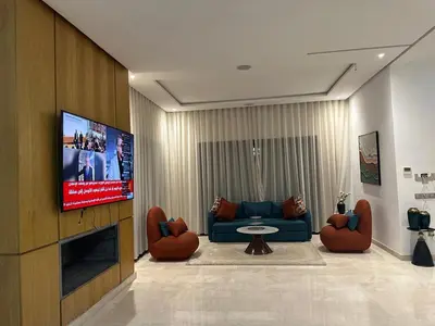 a living room with a couch and a flat screen tv at Villa à louer in Oulad Akkou