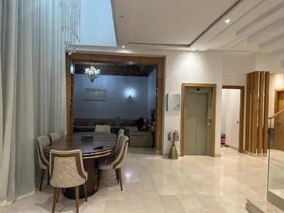 a dining room with a table and chairs at Villa à louer in Oulad Akkou
