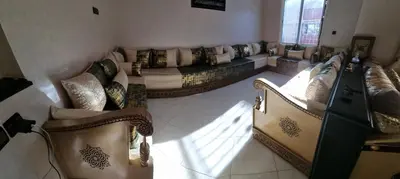 a living room with couches and a tv in a room at Vip charme in Fès