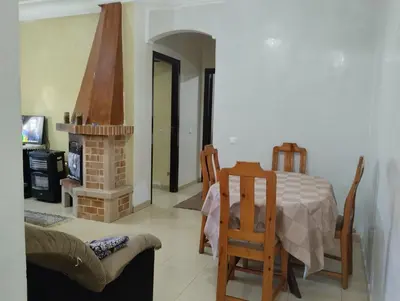 a living room with a table and a fireplace at Dar Yasmine in Ifrane