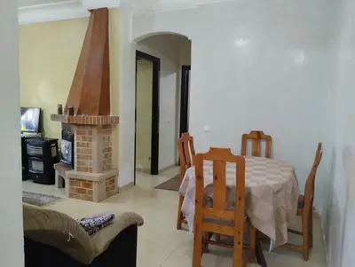 a living room with a table and a fireplace at Dar Yasmine in Ifrane