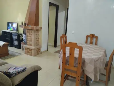 a living room with a table and a fireplace at Dar Yasmine in Ifrane