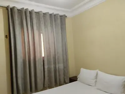a bedroom with a bed and a window with curtains at Dar Yasmine in Ifrane