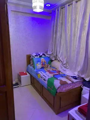 a small bed in a room with purple lighting at Jnane meknes 2 in Meknès