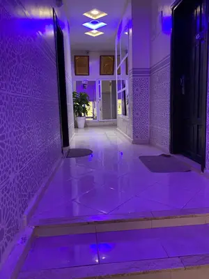 an empty hallway with purple lights on the floor at Jnane meknes 2 in Meknès