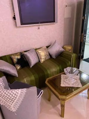 a living room with a green couch and a table at Jnane meknes 2 in Meknès