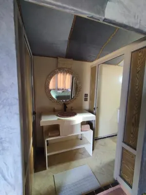 a bathroom with a mirror and a white sink at ChariF Luxury Camp in Rissani