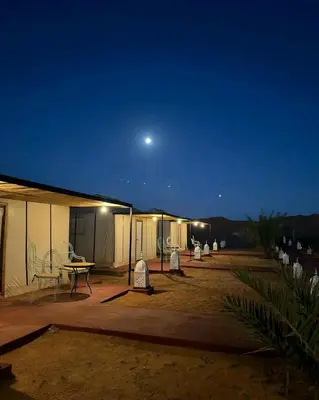 a couple of tents with a moon in the sky at Luxury sahara in Merzouga