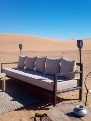 a couch sitting in the middle of the desert at TRIP Merzouga luxury camp in Hassilabied
