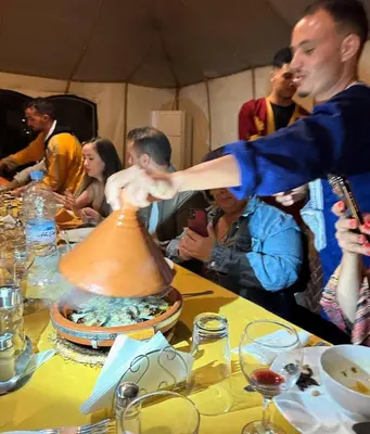 a man making a clay pot on a table at TRIP Merzouga luxury camp in Hassilabied