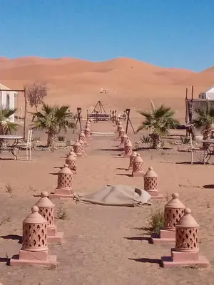 a row of barriers in the sand in the desert at TRIP Merzouga luxury camp in Hassilabied