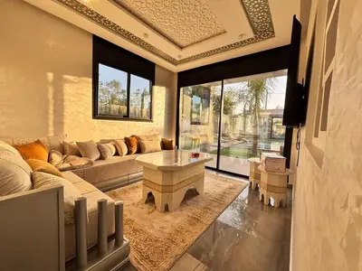 a living room with a couch and a table at Villa Atlas in Aghmat