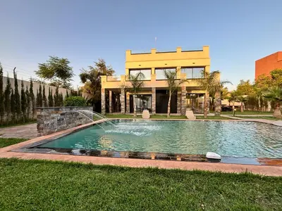 a large swimming pool in front of a building at Villa Atlas in Aghmat