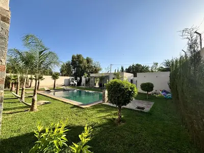 a yard with a swimming pool and a house at Villa Atlas in Aghmat
