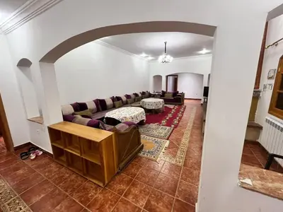 a living room with a couch and a table at Ferme avec piscine et vue panoramique in Khenifra