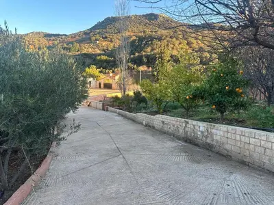 a street with a retaining wall and a mountain at Ferme avec piscine et vue panoramique in Khenifra