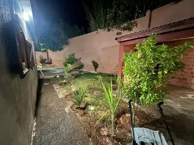 a garden at night with a bench and plants at Ferme avec piscine et vue panoramique in Khenifra