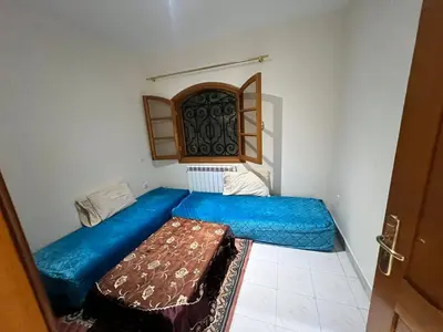 a small room with a blue bed and a window at Ferme avec piscine et vue panoramique in Khenifra