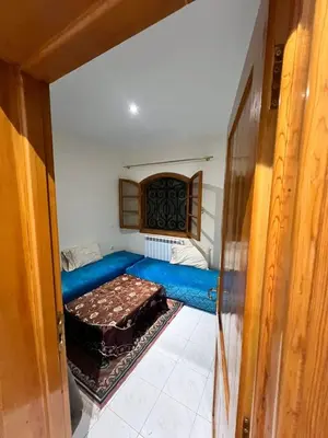 a bedroom with a blue bed in a room at Ferme avec piscine et vue panoramique in Khenifra