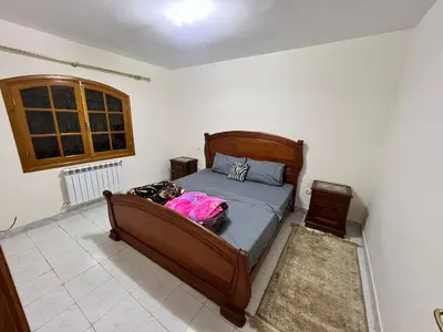 a bedroom with a bed with a wooden frame at Ferme avec piscine et vue panoramique in Khenifra