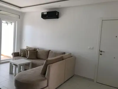 a living room with a couch and a table at Spacious Apartment PoolAir Conditioning Terrace in Oulad Akkou
