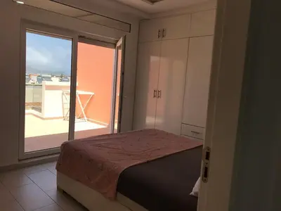 a bedroom with a bed and a large window at Spacious Apartment PoolAir Conditioning Terrace in Oulad Akkou