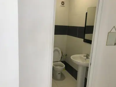 a bathroom with a toilet and a sink at Cozy Apartment Near the Beach & Public Pool in Oulad Akkou