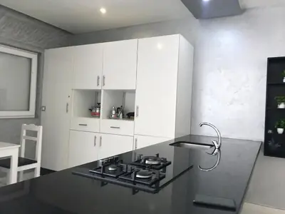 a kitchen with white cabinets and a stove top oven at Family Flat Pool Chill Vibes in Oulad Akkou