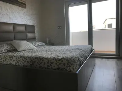 a bedroom with a bed and a large window at Family Flat Pool Chill Vibes in Oulad Akkou