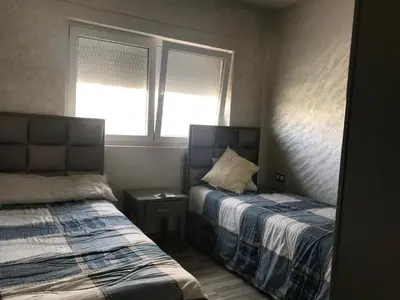 a bedroom with two beds and a window at Family Flat Pool Chill Vibes in Oulad Akkou