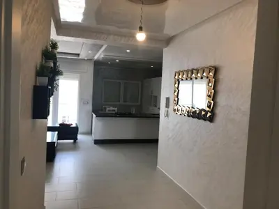 a living room with a mirror on the wall at Family Flat Pool Chill Vibes in Oulad Akkou
