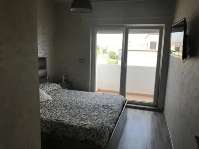 a bedroom with a bed and a large window at Family Flat Pool Chill Vibes in Oulad Akkou