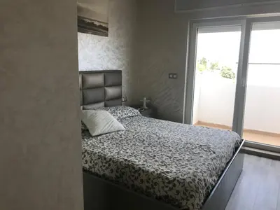 a bedroom with a bed and a large window at Family Flat Pool Chill Vibes in Oulad Akkou