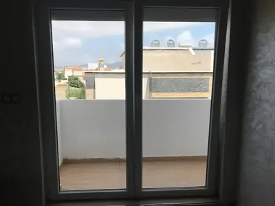 a window with a view of a building at Family Flat Pool Chill Vibes in Oulad Akkou